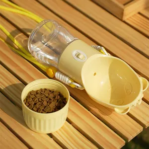 Tragbare gelbe Haustier-Wasserflasche mit Schultergurt und Futternapf auf Holztisch