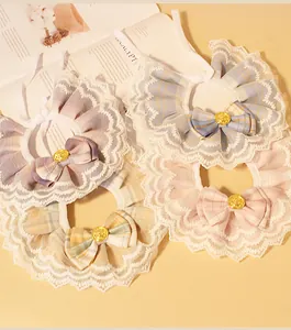 Close-up of elegant lace pet collars with colorful plaid bows and gold medallions.