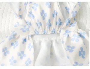 Détail du motif trèfle bleu et de la taille à volants sur la robe blanche pour chiens