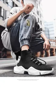 Λεπτομέρεια μαύρου αναπνεύσιμου sneaker-κάλτσα με χοντρή λευκή σόλα και κορδόνια