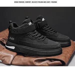 Dettaglio ravvicinato di sneakers alte nere da uomo su una superficie in pelle marrone.