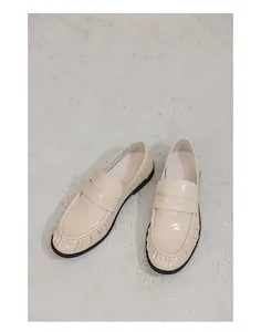 Elegant cream loafers in textured leather for versatile casual and formal style.