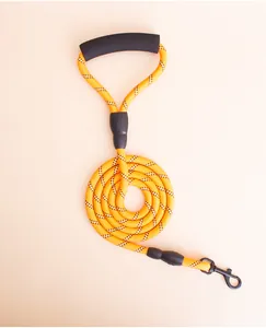 Detailed close-up of the reflective yellow braided dog leash with black foam handle