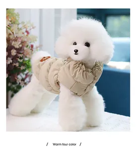 Detailed view of a fluffy white dog wearing a warm beige winter puffer vest for pets