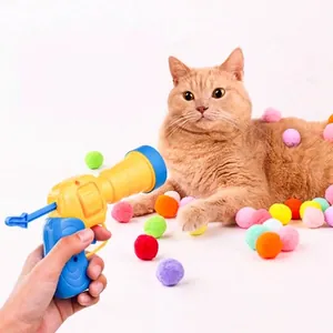 Dettaglio di un lancia palline per gatti con palline di peluche colorate e gatto