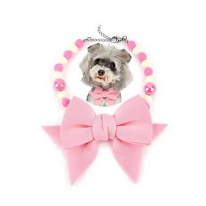 Detailed view of a colorful beaded pet collar featuring a large elegant pink bow