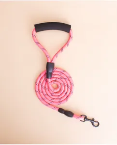 Close-up detail of a pink reflective round dog leash with soft black foam padded handle