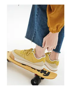 Gros plan détaillé de baskets rétro jaunes à semelle épaisse et lacets sur un skateboard