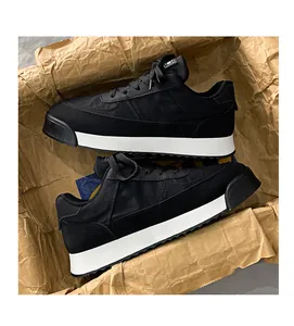 Vue détaillée de baskets noires respirantes avec une semelle compensée blanche épaisse.