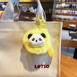 Adorable llavero de bola de peluche amarillo con cara de panda en un bolso de lona
