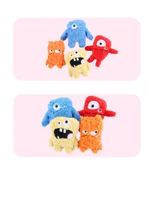 Dettaglio di quattro colorati mostri di peluche per cani con grandi occhi e denti