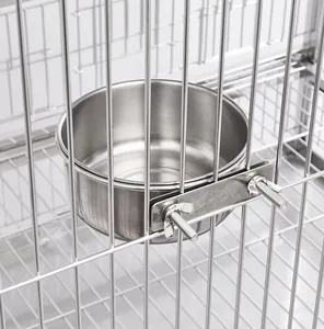 Detail view of a stainless steel pet bowl securely attached to a wire cage with screws