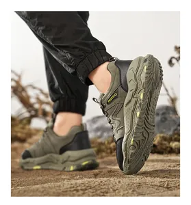 Detail view of a men's olive green outdoor hiking shoe with durable sole on sandy ground