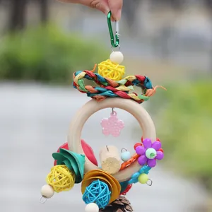 Close-up of colorful wooden bird toy featuring rattan balls and corn husk flowers