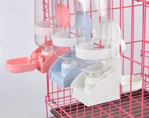 Detail view of colorful automatic pet water dispensers mounted on a pink wire cage