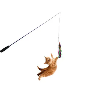 Action shot of a ginger cat jumping to catch a colorful telescopic teaser wand