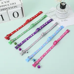 Detailed view of colorful pet collars with paw prints and bells in a set