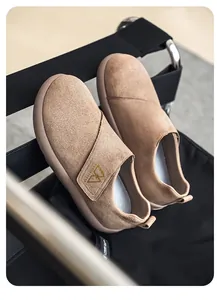 Vista detallada de mocasines de ante beige de lujo en una silla moderna.