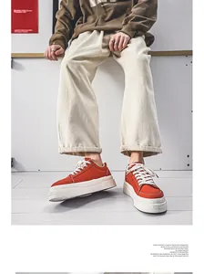 Detailed side view of orange Harajuku style platform canvas sneakers for men on a model