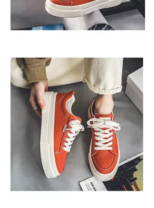 Close-up of orange canvas sneakers with thick white soles and 'Fashion' tag