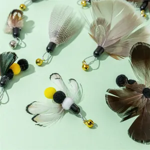 Detailansicht von insektenförmigen Katzenstab-Ersatzteilen mit Federn und Glöckchen.
