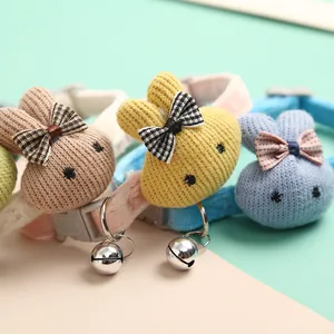 Close-up of cute knitted cartoon rabbit pet collars with bells in pastel colors