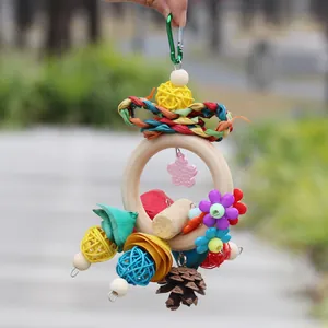 Handheld bird toy featuring colorful rattan balls, pinecone, and natural wooden ring