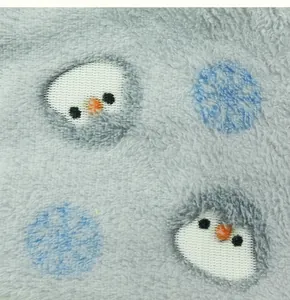 Close-up of soft gray plush fabric with cute penguin and snowflake patterns for pet vest