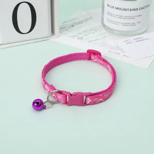 Detailed view of pink paw print pet collar with a purple bell and secure buckle for cats