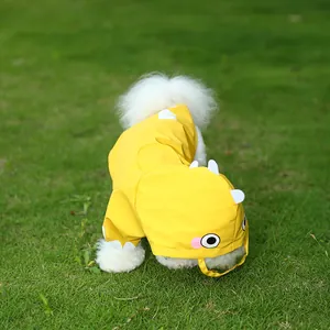 Cute yellow cartoon dinosaur pet raincoat for small dogs on green grass background.