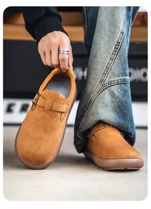 Primer plano de mocasines de ante camello de primera calidad con hebilla y suela de goma.