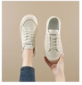 Detailed view of cream white canvas mule sneakers with FASHION label on tongue