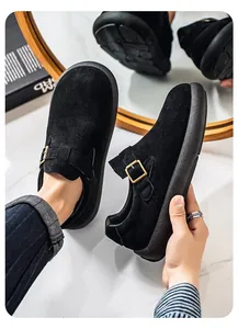 Primer plano de mocasines de ante negro para hombre con hebilla metálica y suela gruesa
