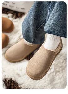 Close-up of tan suede plush-lined clogs worn with denim for a stylish cozy winter look