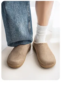 Close-up view of khaki fleece-lined clogs worn with white socks and denim jeans