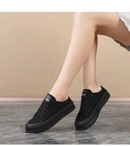 Detail view of women's black canvas platform sneakers on a model with FASHION label