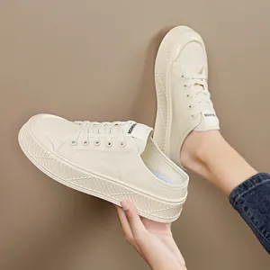 Cream white canvas slip-on sneakers with thick soles and lace-up design