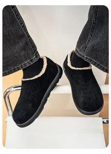 Detail view of plush black slip-on shoes with cream fleece lining and sturdy soles