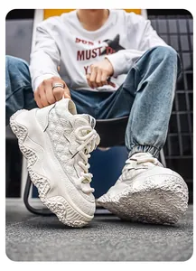 Close-up view of white leather high-top bread sneakers with chunky textured sole.