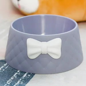Macro detail of macaron purple pet bowl with diamond pattern and cute white bowknot decoration