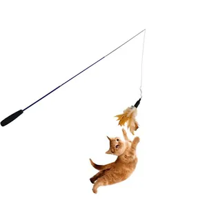 Orange tabby cat jumping to catch feathers on a long telescopic interactive wand