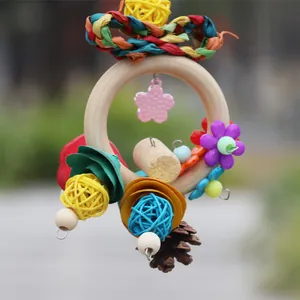 Colorful bird toy with wooden ring, rattan balls, and plastic flowers for small parrots