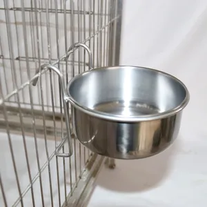 Detailed view of a durable stainless steel bird feeder bowl hanging securely on a wire cage