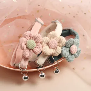 Close-up of cute cat collars with plush flowers and silver bells in soft colors