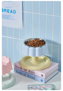 Bol surélevé en inox pour chat sur des livres pastel, décor de style de vie