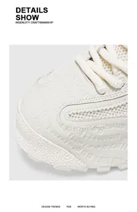 Vue macro de baskets blanches en mesh avec détails gaufrés et textures de qualité.