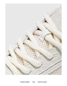 Vue détaillée macro du mesh respirant et des lacets épais sur des baskets blanches massives