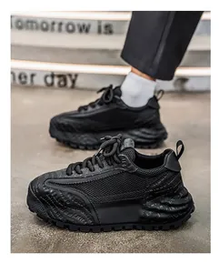 Détail latéral des baskets noires épaisses pour hommes avec empiècements en mesh