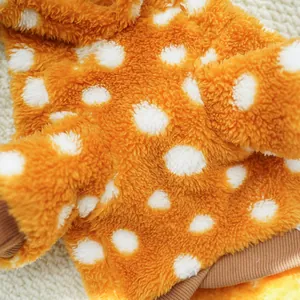 Macro detail of soft orange and white polka dot fleece fabric for pet clothes.