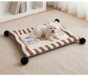 Detailed lifestyle view showing a striped pet mat with black pom-poms and a white dog